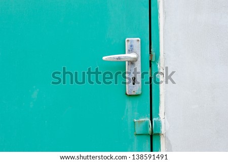Aluminium door knob on the green door