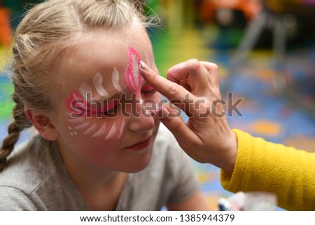Animator draws a girl drawing on the face at a party.