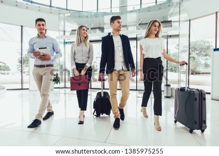 Business people talk and walk together with digital tablet tablet and luggage.