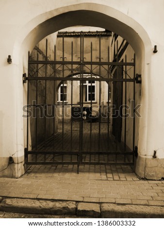 Arched passage to the courtyard gateway with  grating, Riga, Latvia.
