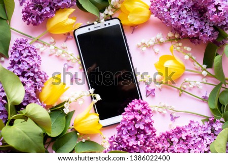 phone with tulips, lilac and lilies of the valley . present