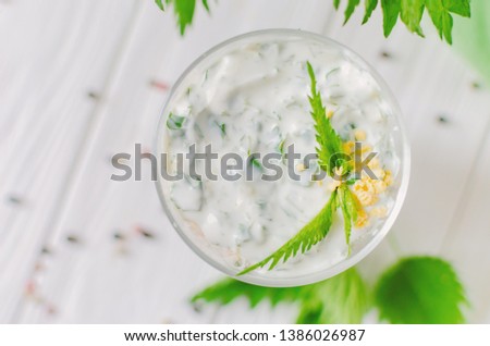 Exotic salad with nettles and eggs in a glass lined in layers. Bright spring salad with nettle leaves