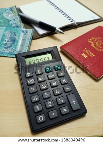 calculator ,  money , pen , note book and passport in wooden table background . planning for holiday stock photo -image
