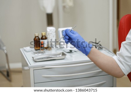 dental instruments in hand blue glove on dentistry background