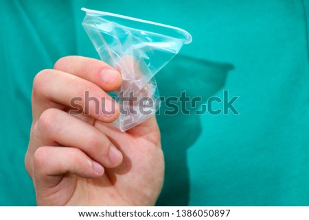 Crumpled plastic disposable cup in hand