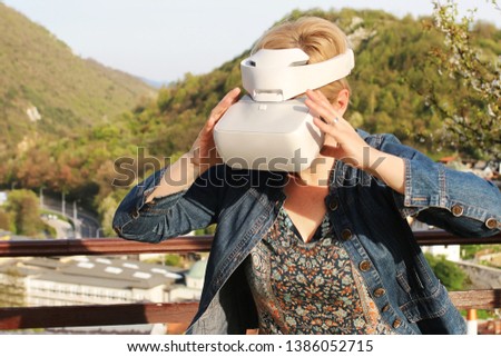 Middle aged woman testing virtual reality glasses for the first time. Unique sensations embrace her. A virtual surrounding 360 3 D view using virtual reality gear 360 glasses 