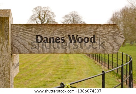 Wooden direction sign to Danes Wood in the English countryside