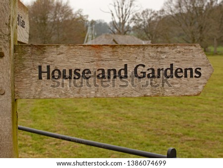 Wooden direction sign to House and Gardens in the English countryside