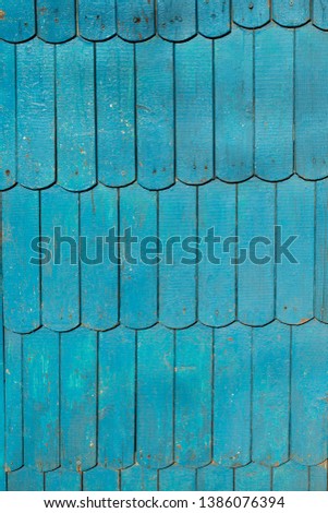 The plane of the wall paneling. Wooden texture. Old board. The peeling paint is blu.