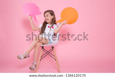 A cute little girl with a speech icon on a pink background sits on a chair .The concept of communication