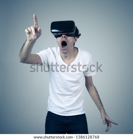 Amazed funny man using VR headset glasses touching and interacting with virtual reality world , feeling excited exploring and having fun in 360 VR simulation. Innovation and new technology concept.