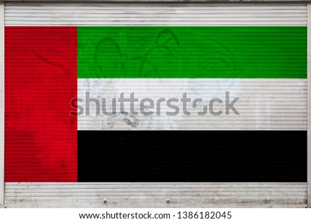 Close-up of old metal wall with national flag of United Arab Emirates. Concept of United Arab Emirates export-import, storage of goods and national delivery of goods. Flag in grunge style