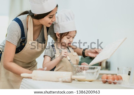 Happy family mom teaching cute girl preparing and cooking healthy salad for the first time. first lesson and healthy lifestyle concept.