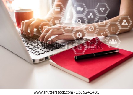 Social media and Marketing virtual icons screen of businesswoman typing keyboard with laptop computer at office.