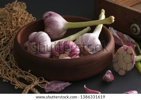Fresh garlic. Kind of garlic in a clay plate sitting against a dark background. Mill food. Harvest Food stock photography. Healthy food. food photography - Image