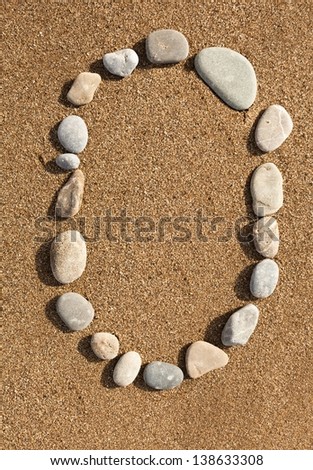 English letters, numbers alphabet stones laid out on the sand
