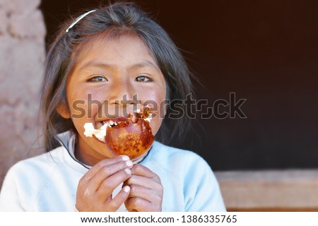 Smiling native american girl eats granadilla.