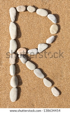 English letters, numbers alphabet stones laid out on the sand