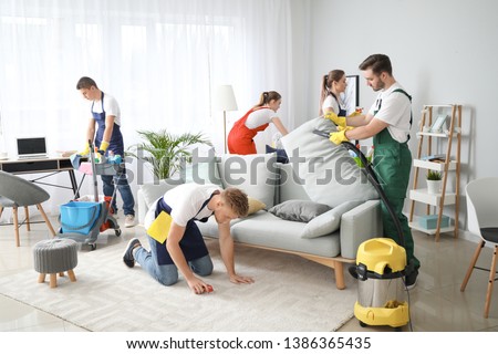 Team of janitors cleaning room Royalty-Free Stock Photo #1386365435