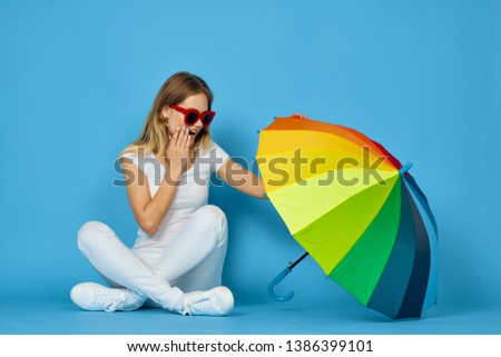   woman in glasses with umbrella color studio blue background fashion                             