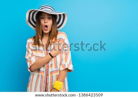 Young woman in bikini in summer holidays surprised and pointing side