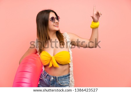 Young woman in bikini in summer holidays pointing with the index finger a great idea