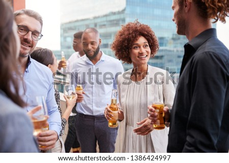 Office colleagues socialising with drinks in the city after work Royalty-Free Stock Photo #1386424997