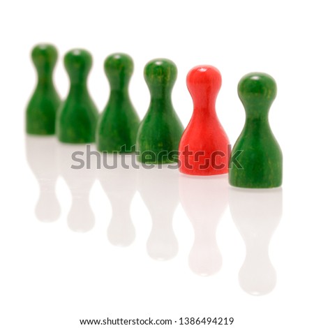 Row of wooden green figures and one red figure. Teamwork, balance and divercity concept.