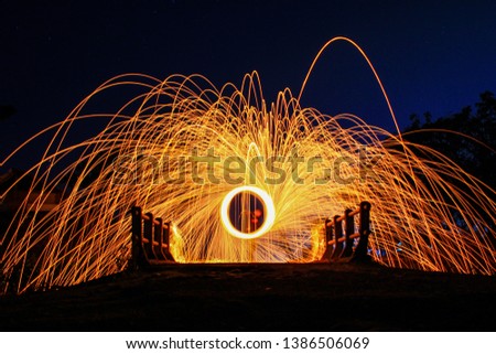 Showers of glowing sparks from spinning steel wool on the bridge