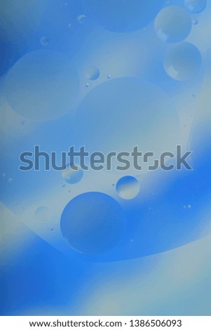 Blurred abstract background. Blue and light blue circles and wavy lines of different sizes on a gray background. Cropped shot, vertical, a lot of free space, nobody. Concept of design.
