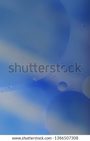 Blurred abstract background. Blue and light blue circles and wavy lines of different sizes on a gray background. Cropped shot, vertical, a lot of free space, nobody. Concept of design.