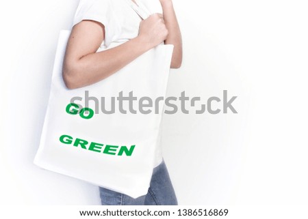 Girl with a white shopping bag. Shopping bag with the words "Go green". Concept: ecology, go green. Copy space