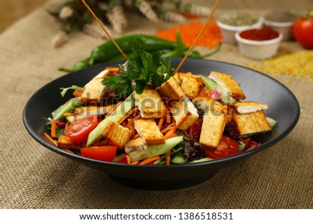 Fresh mixed vegetables salad in black bowl
