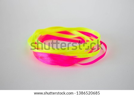 Pink and yellow ribbons on a white background