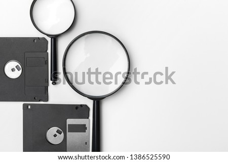 magnifying glass inspecting on floppy disk concept
