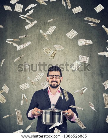 content super excited man with boil pan under money dollar bills rain on gray wall background 