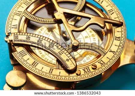 Compass on blue background, top view