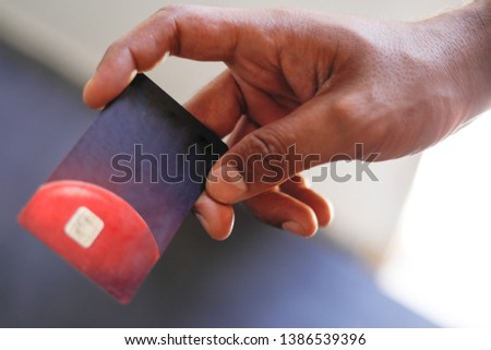 Hand holding credit card with black and white background. 

