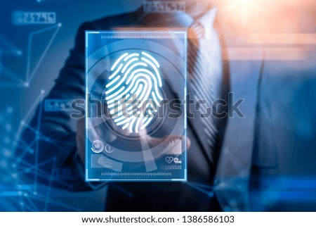 The abstract image of the businessman use a thumb scanning overlay with futuristic hologram. the concept of fingerprint, biometric, information technology and cyber security.