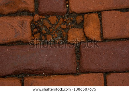 Closeup red brick cobblestone abstract texture background with dirt and detail.