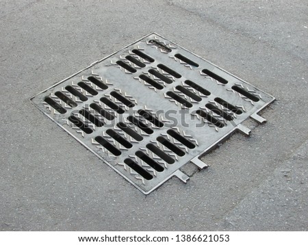 Metal grating on the drainage system Outdoor rectangular drainage holes To prevent flooding in urban areas On the asphalt background.