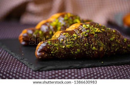 two chocolate croissants with pistachios. French pastry, croissant in chocolate.