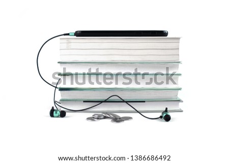 Concept of cheap audio books. Blue headphones and mobile on the stack of books. White background with space for text