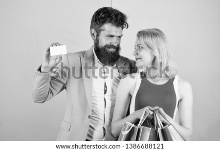 Paying while dating. Couple with luxury bags in shopping mall. Man bearded hipster hold credit card and girl enjoy shopping. Ask man to purchase lots presents for girlfriend. Couple enjoy shopping.
