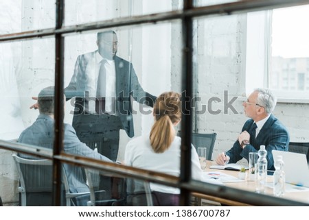 selective focus of african american business coach talking and gesturing near coworkers 