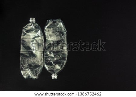 Two plastic bottles with recycling code PET 01 isolated on black background