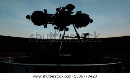 the huge of projector in interior of planetarium with the darkness of the auditorium