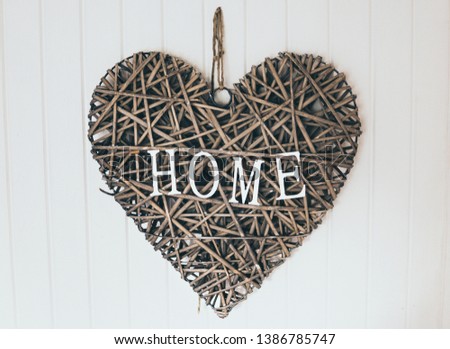 interior wooden heart with home written on it haning on a white wall