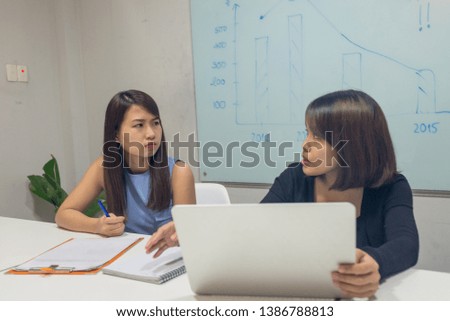 Two office ladies talking about business plan in meeting room