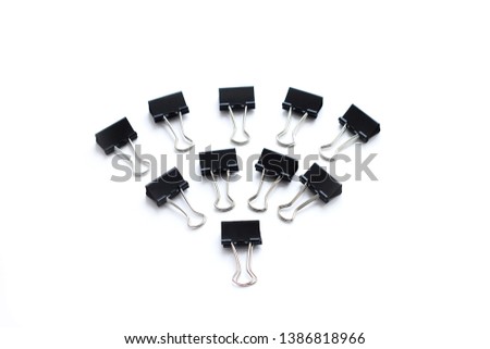 set of black office binder clips fanned out on a white background